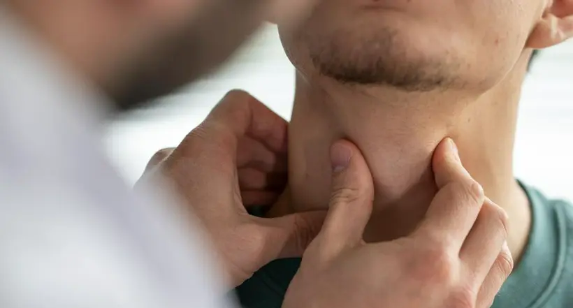 Médico examinando a paciente a propósito de cómo tratar la tiroides de forma natural
