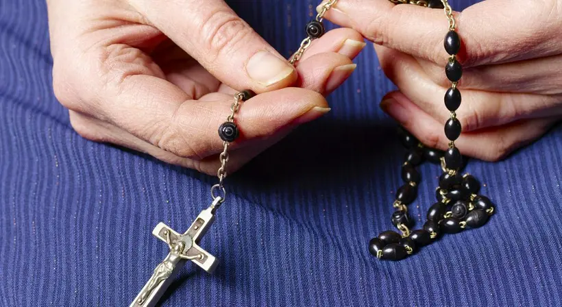 Mujer con un rosario en nota sobre cómo se reza
