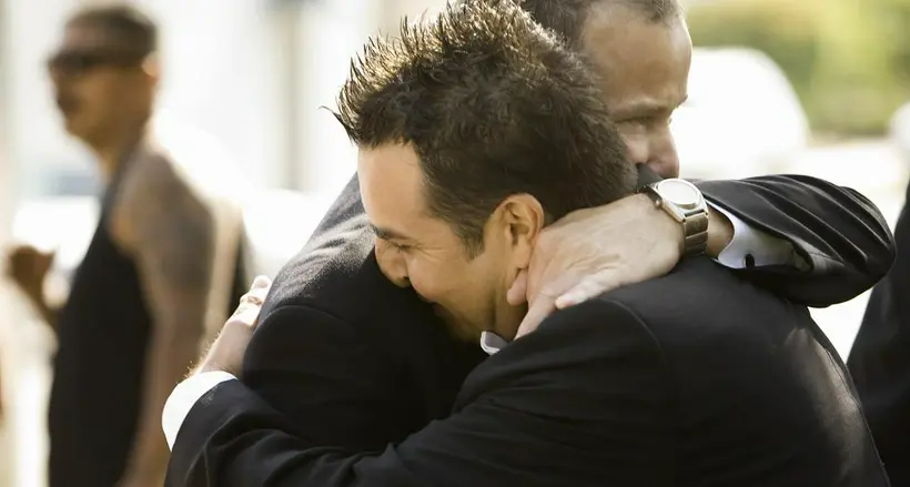 Personas abrazándose ilustra nota de gemelos que se reencuentran luego de 20 años de estar separados.