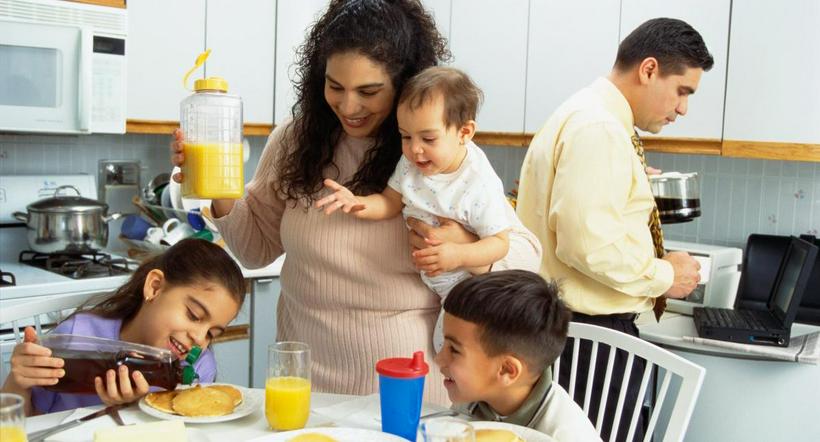 Foto de referencia de una ama de casa sirviendo el desayuno de sus hijos.