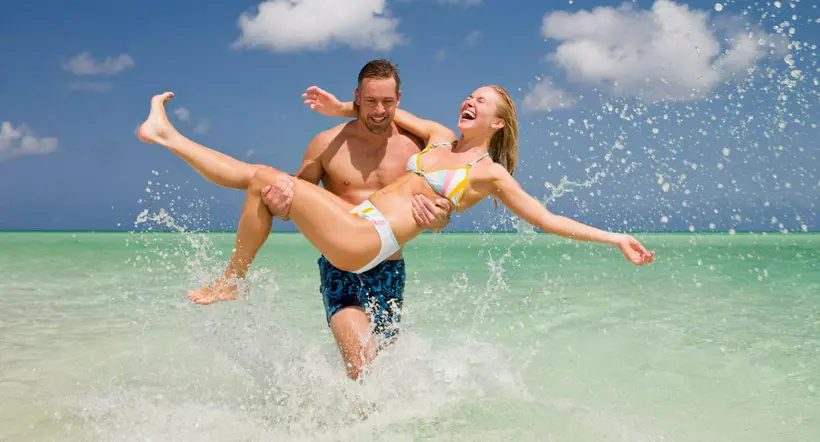Foto de pareja en la playa a propósito de resorts en el Caribe para festejar San Valentín