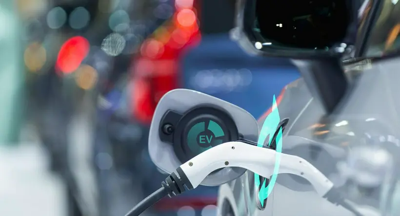 EV Car or Electric car at charging station with the power cable supply plugged in city blurred background,  car fueling station connected power cable alternative sustainable eco energy.