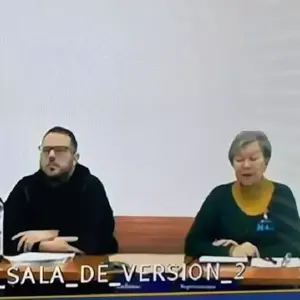 John Poulos, durante su audiencia de imputación, junto a la traductora del caso.