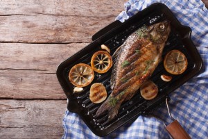Grilled carp with lemon in a grill pan , horizontal view from above