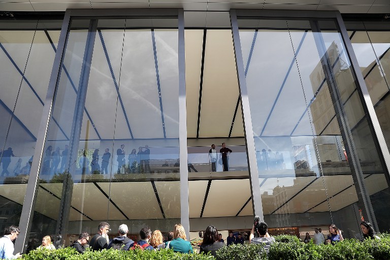 SAN FRANCISCO, CA - MAY 19: Members of the media look on as 42-foot tall sliding glass doors open during a press preview at the new flagship Apple Store on May 19, 2016 in San Francisco, California. Apple is preparing to open its newest flagship store in San Francisco's Union Square on Saturday May 21. The new store features new design elements as well as community programs including the "genius grove" where where customers can get support under a canopy of local trees and "the plaza" a public space that will be open 24 hour a day. Visitors will enter the store through 42-foot tall sliding glass doors. Justin Sullivan/Getty Images/AFP