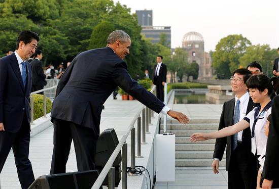 Obama y el primer ministro nipón, Shinzo Abe, saludan a una estudiante tras el homenaje a las víctimas de la bomba nuclear. Foto de EFE.