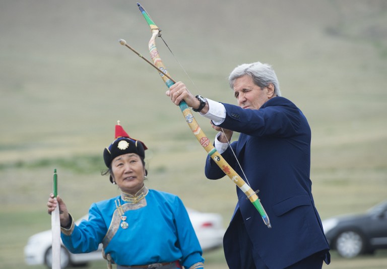 US Secretary of State John Kerry shoots a bow and arrow as he participates in a Naadam ceremony, a competition which traditionally includes horse racing, Mongolian wrestling and archery, in Ulan Bator, Mongolia on June 5, 2016. Kerry arrived in Mongolia on June 5, the latest senior US official to make the trip to the mineral-rich country neighboured by Russia and China. / AFP PHOTO / POOL / SAUL LOEB