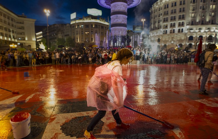 Protestors disperse color paint during a protest against the government, at central square, during an anti-government protest in Skopje on June 6, 2016, in a series of protests dubbed Colourful Revolution. Macedonia's president on June 6, 2016 said he was revoking all the controversial pardons he had granted in April to dozens of people implicated in a huge wiretapping scandal. President Gjorge Ivanov had on April 12 said he was halting probes into 56 Macedonians suspected of involvement in the scandal -- a surprise decision that sparked international condemnation and angry street protests. / AFP PHOTO / Robert ATANASOVSKI
