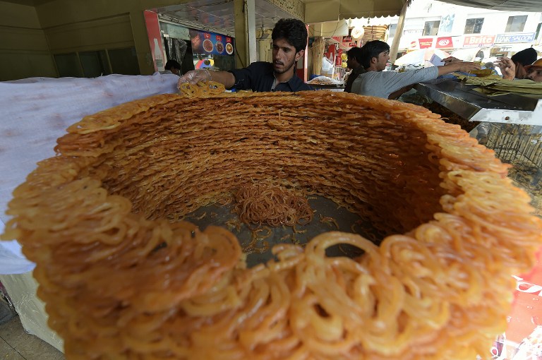 Pakistani bakers prepare Iftar food for Muslims breaking their fast on the first day of fasting month of Ramadan, at a market in Islamabad on June 7, 2016. Islam's holy month of Ramadan is celebrated by Muslims worldwide marked by fasting, abstaining from foods, sex and smoking from dawn to dusk for soul cleansing and strengthening the spiritual bond between them and the Almighty. / AFP PHOTO / AAMIR QURESHI