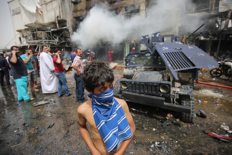 Iraqis check the scene of a car bomb attack in the mostly Shiite neighbourhood of Baghdad Jadida in the Iraqi capital on June 9, 2016. A suicide car bomb attack near a military base north of Baghdad and another blast near a market in the Iraqi capital killed at least 18 people, police said. / AFP PHOTO / AHMAD AL-RUBAYE