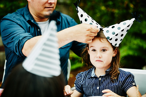 Young girl wearing two party hats