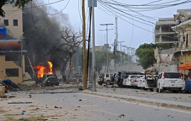 Fire is seen at the scene of a car bomb attack claimed by Al-Qaeda-affiliated Shabaab militants which killed at least 5 people, on the Naasa Hablood hotel in Mogadishu on June 25, 2016. The hotel in southern Mogadishu is often used by politicians and members of the Somali diaspora visiting the city. The attack came just three weeks after another assault quickly claimed by the Al-Qaeda-linked Shabaab group on the city's Ambassador hotel left 10 dead including two lawmakers when a huge car bomb ripped the front off the six-storey building. / AFP PHOTO / MOHAMED ABDIWAHAB