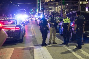 Police stand near a baracade following the sniper shooting in Dallas on Thursday, July 7, 2016. A fourth police officer was killed and two suspected snipers were in custody after a protest late Thursday against police brutality in Dallas, authorities said. One suspect had turned himself in and another who was in a shootout with SWAT officers was also in custody, the Dallas Police Department tweeted. / AFP PHOTO / Laura Buckman