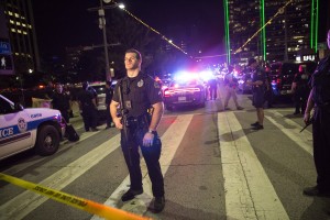 Police officers stand guard at a baracade following the sniper shooting in Dallas on July 7, 2016. A fourth police officer was killed and two suspected snipers were in custody after a protest late Thursday against police brutality in Dallas, authorities said. One suspect had turned himself in and another who was in a shootout with SWAT officers was also in custody, the Dallas Police Department tweeted. / AFP PHOTO / Laura Buckman