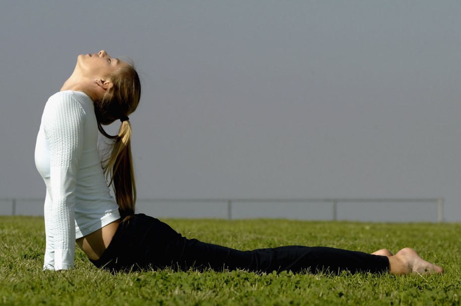 Mujer practicando yoga en un parque - pulzo.com