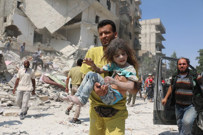 En Alepo, Siria, un hombre cargó a una niña, luego de la explosión de 2 bombas. Pulzo.com