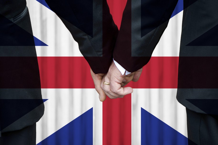 Hombres tomándose de la mano con bandera del Reino Unido al fondo