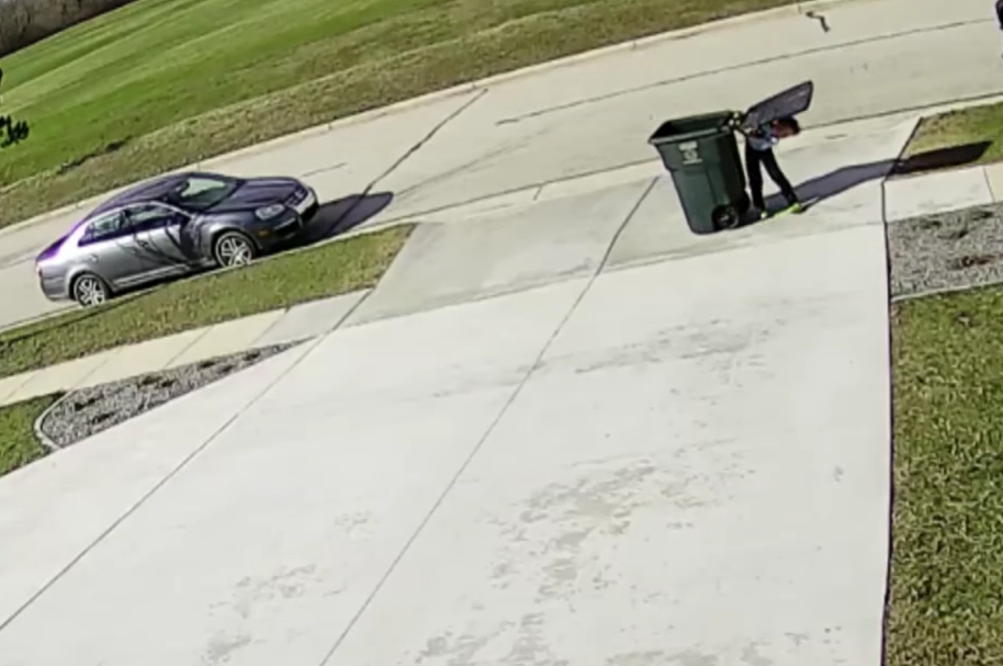 Niño luchando con tanque de basura Niño luchando con tanque de basura