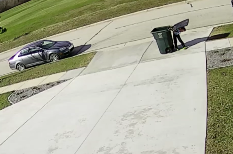 Niño luchando con tanque de basura