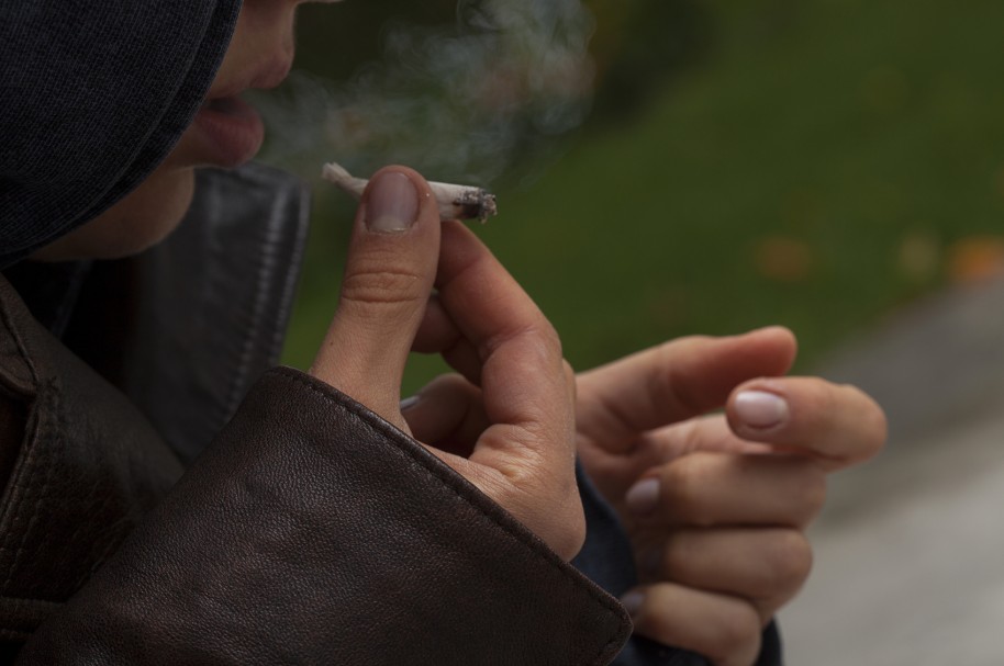 Una joven fuma un porro