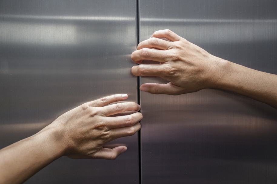 Mujer intenta evitar cierre de puertas de ascensor. Pulzo.com