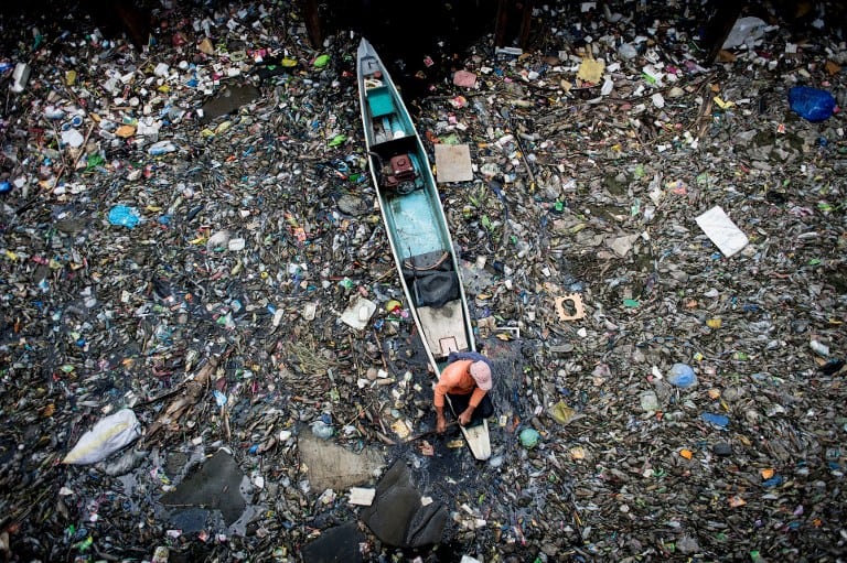 Hombre recolecta basura en río Marilao.