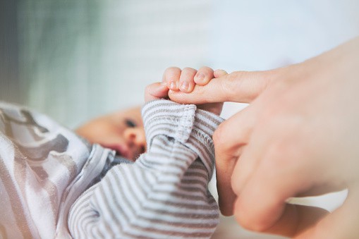 Bebé toma la mano de su madre