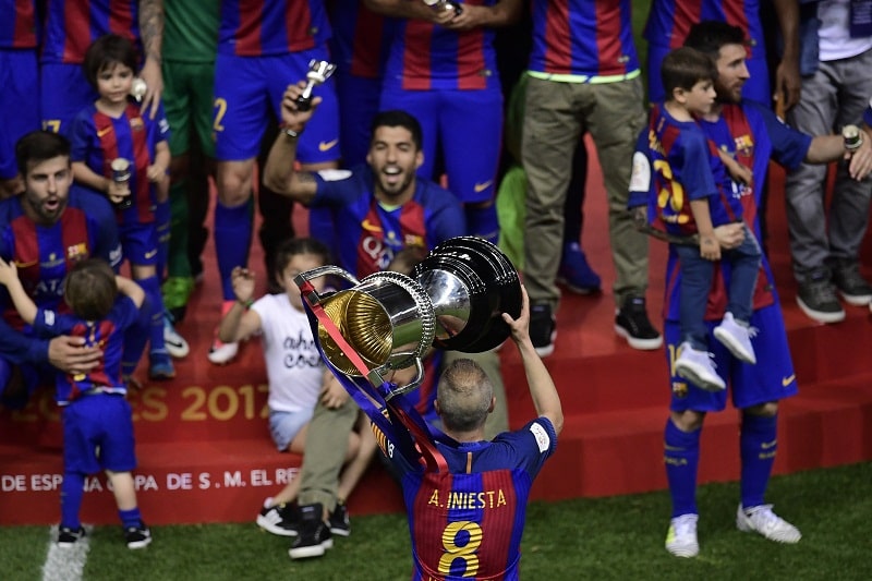Andres Iniesta holds up the cup