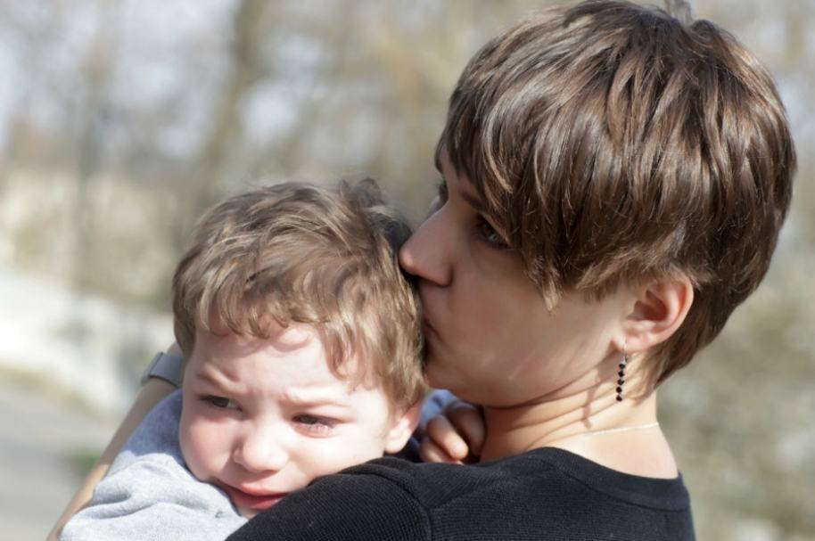 Madre abraza a hijo.
