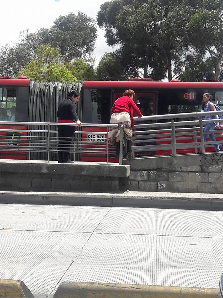 Mujer saltando baranda en estación de Transmilenio