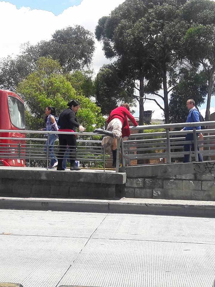 Mujer saltando baranda en estación de Transmilenio
