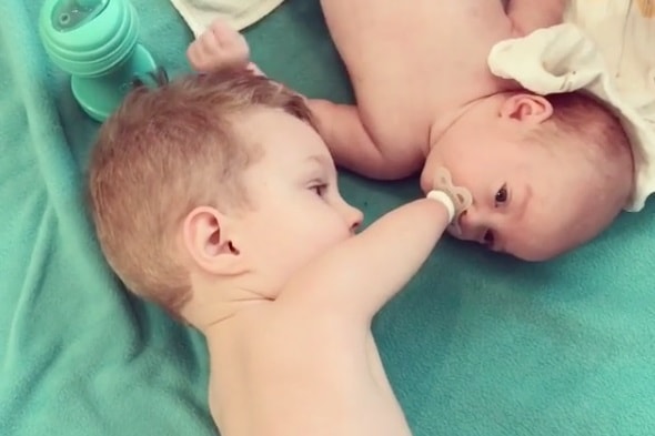 Niño sin brazos que ayuda a su hermano