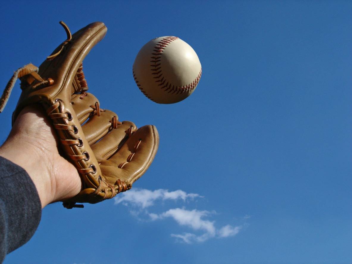 Hombre atrapando una pelota de béisbol. Pulzo.
