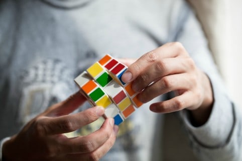 Joven armando un cubo de Rubik. Pulzo.