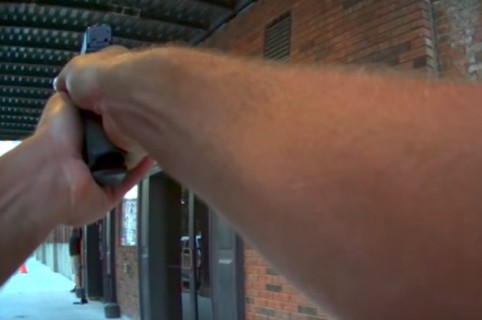 Policía amenaza con su arma a un actor disfrazado de ladrón. Pulzo.