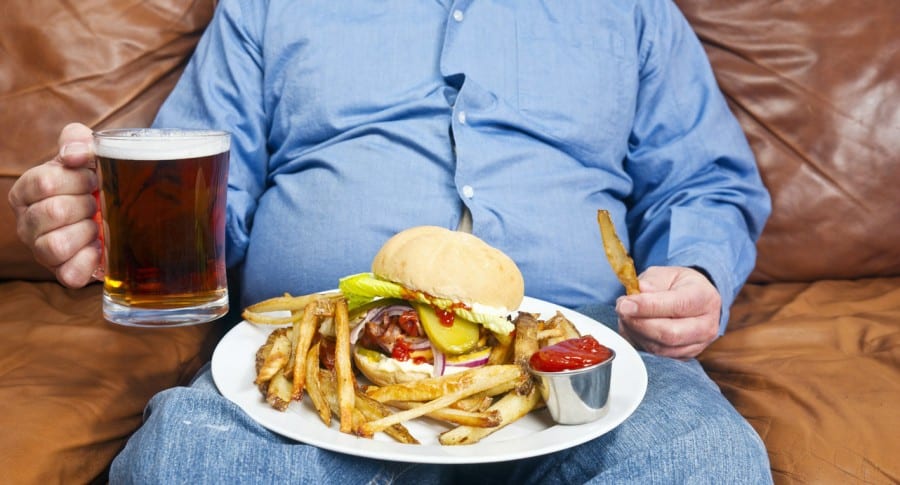 Hombre con sobrepeso y comiendo