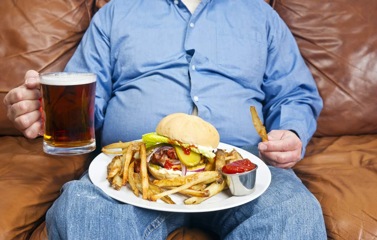 Hombre con sobrepeso y comiendo