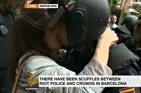 Beso de manifestante a oficial antidisturbios en Barcelona.