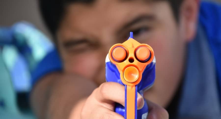 Niño disparando un arma de juguete