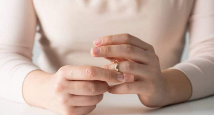 Mujer quitándose el anillo de casada