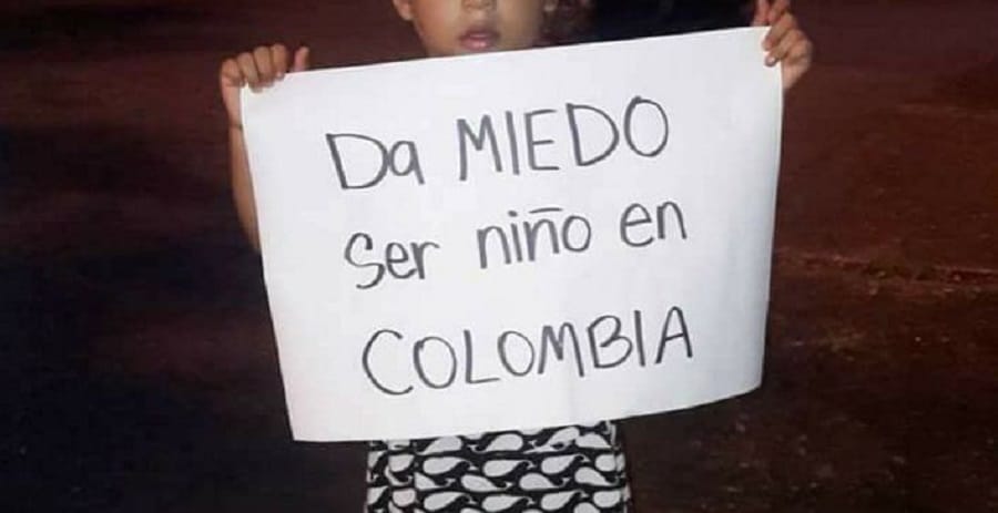 Niño con cartel contra el maltrato infantil