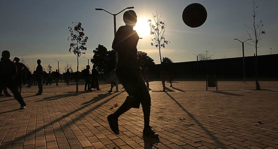 Menor juega con balón de fútbol.
