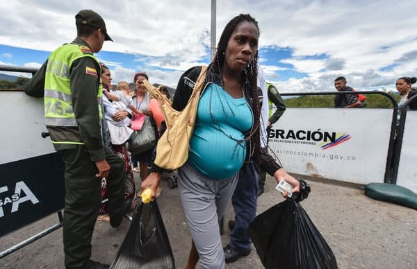 Mujer embarazada cruzando la frontera.