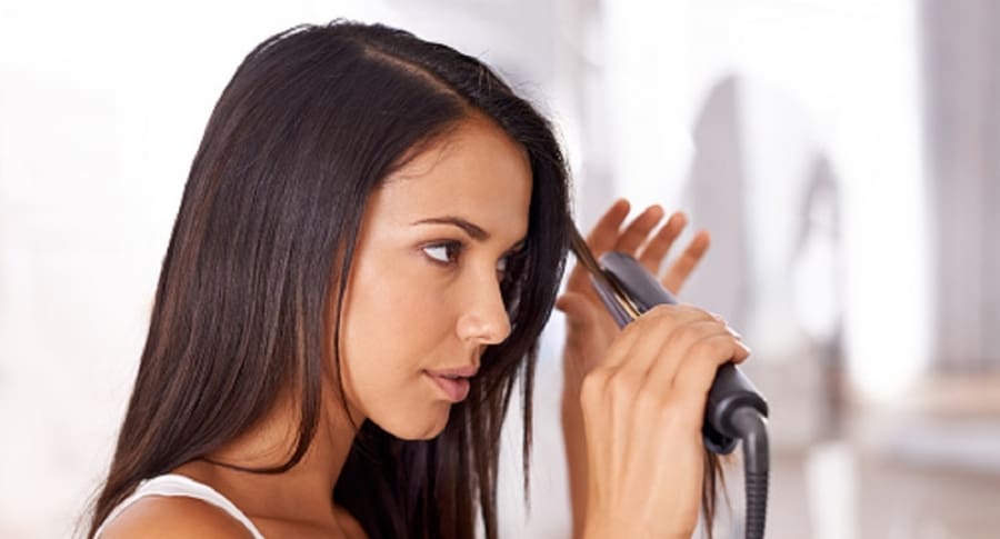 Mujer planchando su cabello