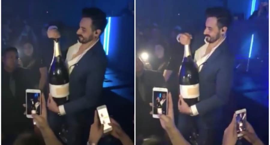 Hombre abre botella de champaña en Ibiza.