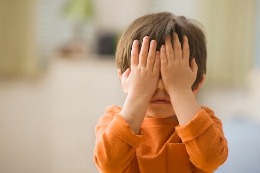 Niño se cubre los ojos