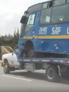 Grúa carga bus del SITP. Pulzo.