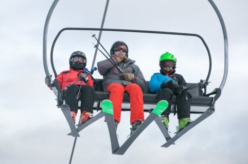 Esquiadores en teleférico de sillas
