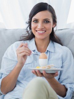 Mujer comiendo huevo