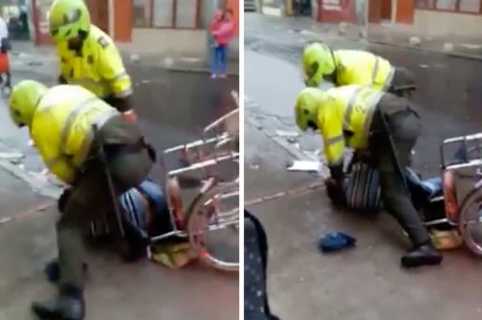 Policías golpeando a hombre en silla de ruedas